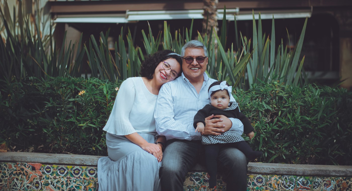Familia mexicana revisando documentos financieros con un consultor